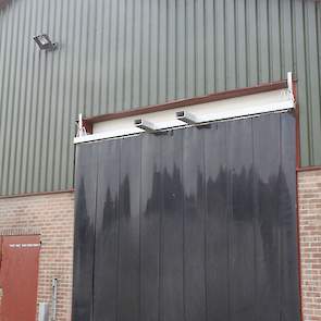 De vleeskuikenhouder laadt zijn kuikens ook wel eens overdag. Om het donker in de stal te houden kan de vleeskuikenhouder met zijn verreiker deze metalen balk met rubber flappen voor iedere roldeur hangen. „Deze kan ik eenvoudig schoon spuiten en is daaro