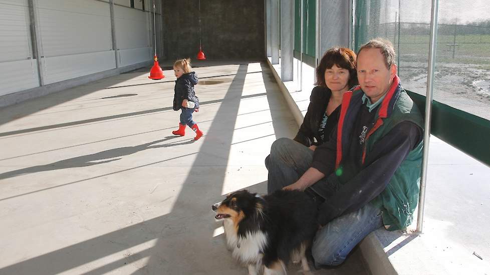 Kleinkind Yara, Arja (51) en Bertus (54) Kieft in de uitloop van hun nieuwe biologische leghennenstal. De leghennenhouders stapten over van scharrel- naar biologische hennen. „De prijzen voor scharreleieren waren de laatste jaren slecht en die voor biolog