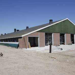 De buitenkant van de verbouwde stal. Na aankoop van het voormalig vrije uitloop leghennenbedrijf in Scherpenzeel sloopte Van de Fliert één van de twee stallen en plaatste de spanten achter de andere stal. De verbouwde stal is 115 meter lang en 18 meter br