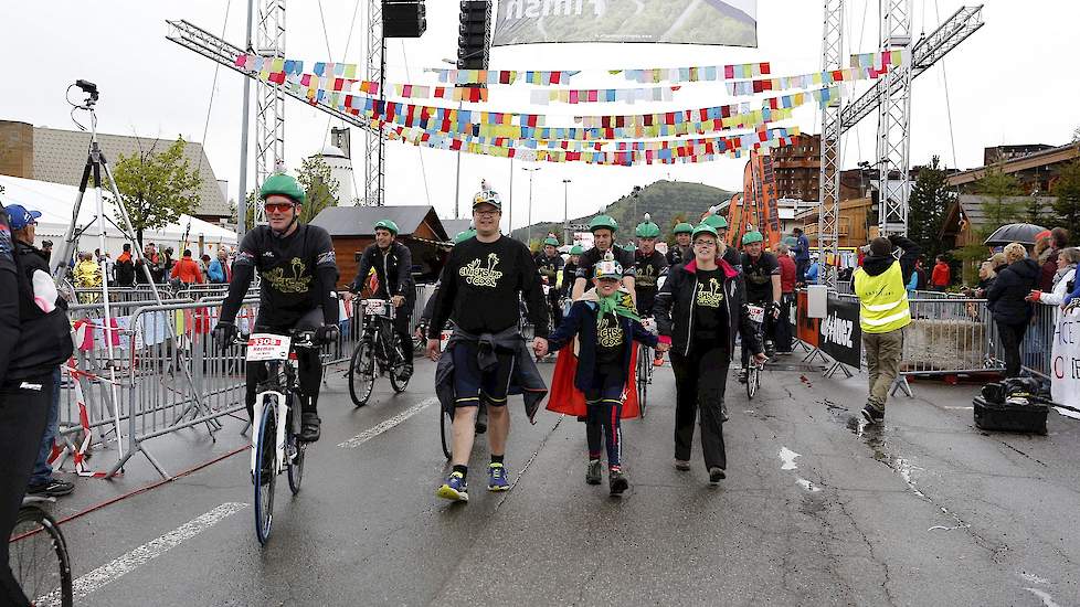 Wandelend en lopend over de finish in Coole kleding. BIG Challenge is de grootste groep binnen Alpe d'HuZes. Op de berg zijn nog veel coole shirts verkocht; de opbrengst gaat 100% naar KWF en het draagt bij aan de promotie van de sector.