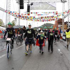 Wandelend en lopend over de finish in Coole kleding. BIG Challenge is de grootste groep binnen Alpe d'HuZes. Op de berg zijn nog veel coole shirts verkocht; de opbrengst gaat 100% naar KWF en het draagt bij aan de promotie van de sector.