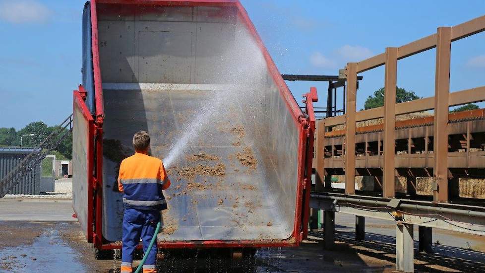 De chauffeur spuit direct de mestcontainers schoon. Rechts is de aanvoerband voor stro zichtbaar. In totaal werken bij Walko 240 medewerkers.