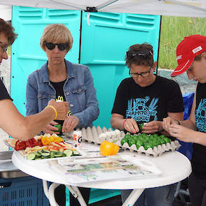 Vrijwilligers pelden de gekookte eieren en sneden appels, komkommers en paprika's. Egga Food uit Ospel sponsorde voor het tweede jaar gekookte groene eieren.