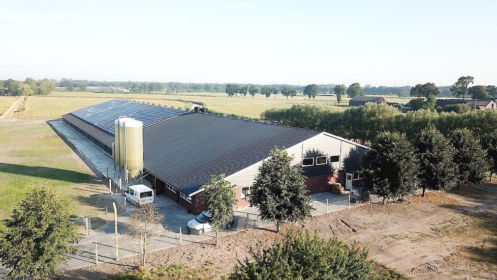 Luchtfoto van de nieuwe stal. De uitloop is zowel links, achter, rechts en voor de stal en wordt nog verder aangeplant. De A30 loopt direct voor langs het perceel achter een bomenrand.