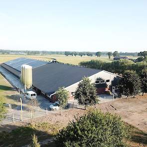 Luchtfoto van de nieuwe stal. De uitloop is zowel links, achter, rechts en voor de stal en wordt nog verder aangeplant. De A30 loopt direct voor langs het perceel achter een bomenrand.